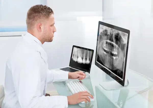 Odontólogo revisando radiografías realizadas con equipos de ortodoncia digital